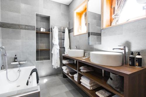 a bathroom with two sinks and a bath tub at Bellevue in Les Gets