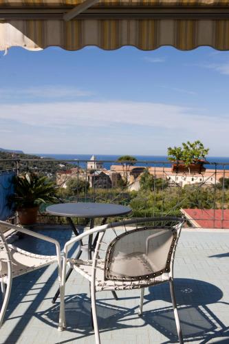 a table and chairs on a patio with a view of the ocean at Hotel La Primavera in Massa Lubrense