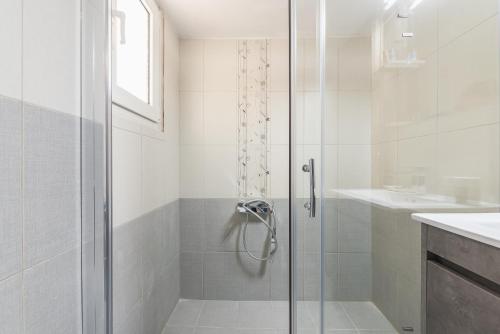 a shower with a glass door in a bathroom at Acropolis 4U! in Athens