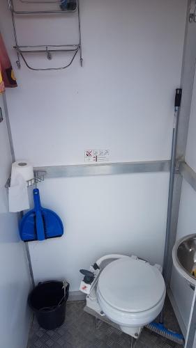 La salle de bains est pourvue de toilettes blanches et d'un lavabo. dans l'établissement Hausboot Krakow am See Forelle 1 und 2, à Krakow am See