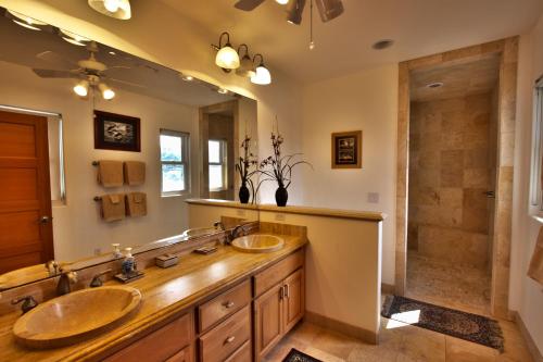 a bathroom with two sinks and a shower at Hale Honu - Spectacular Oceanfront Home w/ central A/C Wading Pool & Hottub in Kailua-Kona