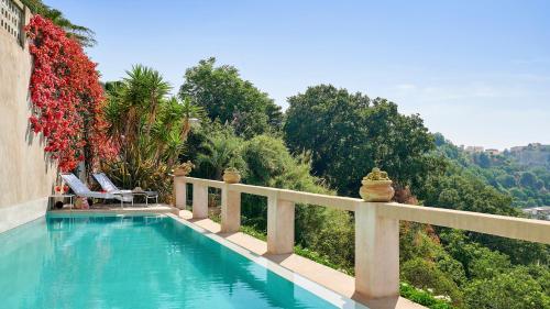 a swimming pool with a fence and trees at Villa Paola in Tropea
