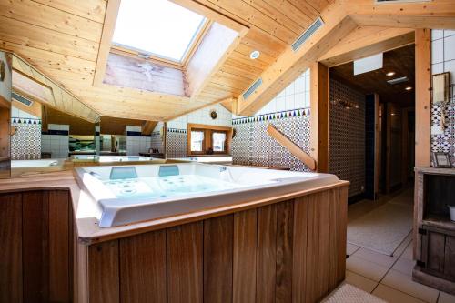 uma grande banheira num quarto com tecto em madeira em Bellevue em Les Gets
