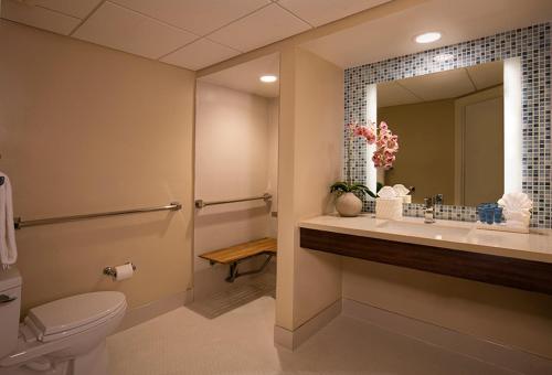 a bathroom with a toilet and a sink and a mirror at Lido Beach Resort - Sarasota in Sarasota