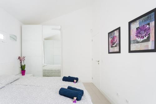 a white bedroom with two beds and a mirror at Apartment Eden Island Village in Adeje