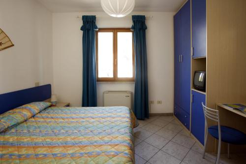 a bedroom with a bed with blue curtains and a window at Casa degli Agrumi in Pomonte