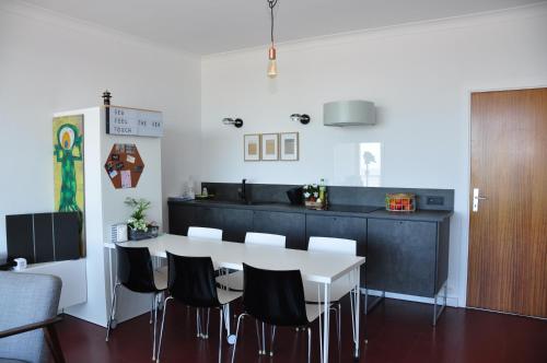a kitchen with a white table and black cabinets at SEA THE SEA - FEEL THE SEA - TOUCH THE SEA in Bredene