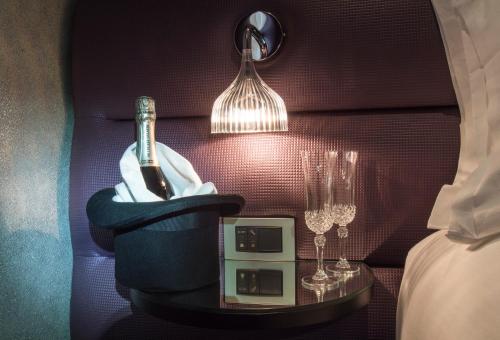 a bottle of wine in a holder on a table with glasses at Hotel Splendor Elysées in Paris