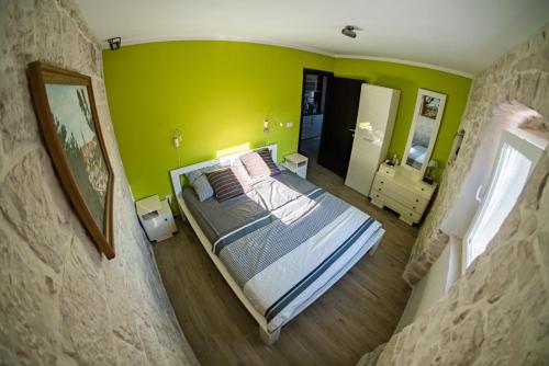 um quarto com uma cama e uma parede verde em Apartment BUGA em Slatine