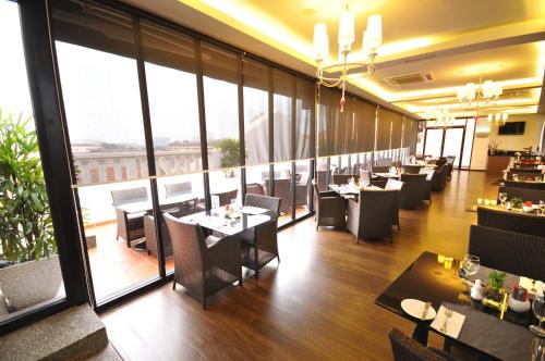 a restaurant with tables and chairs and large windows at The Sterling Boutique Hotel Melaka in Melaka