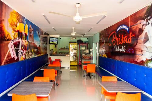 a fast food restaurant with tables and orange chairs at Hotel Arce Plaza in Valledupar