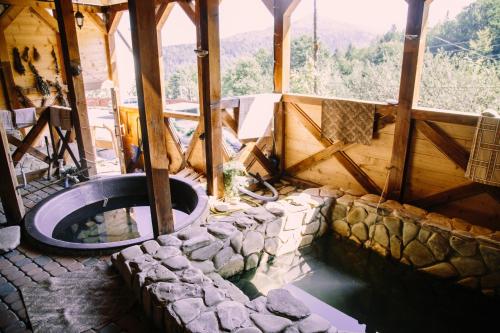 a room with a bath tub in a house with rocks at Vuyko in Yaremche