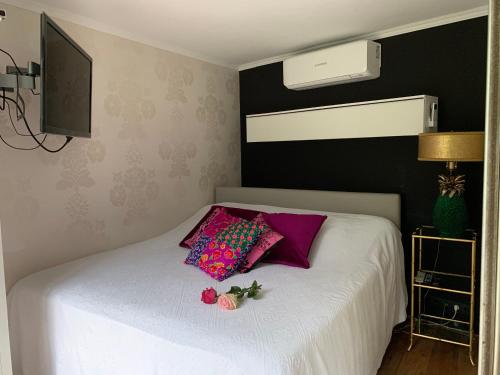 1 dormitorio con cama blanca y almohadas moradas en Place To Be, en Naarden
