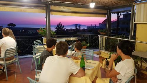 a group of people sitting at a table watching the sunset at Hotel La Primavera in Massa Lubrense