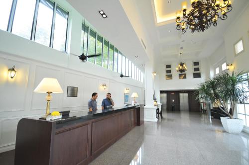 two people standing at a reception desk in a lobby at The Sterling Boutique Hotel Melaka in Melaka