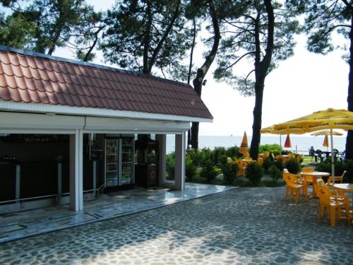 a house with a patio with a table and an umbrella at Villa ReTa Hotel & SPA in Grigoleti
