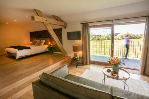 a living room with a bed and a large window at Oversteekhof in Roesbrugge-Haringe