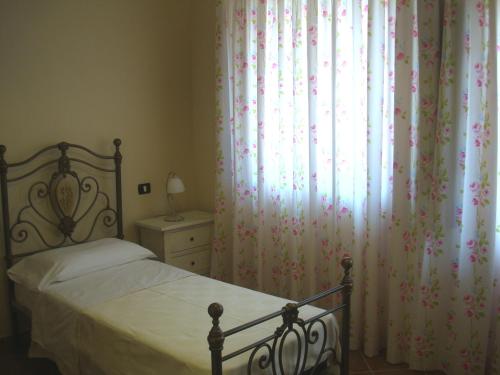 a bedroom with a bed and a window with curtains at Agriturismo Fieri in Botricello