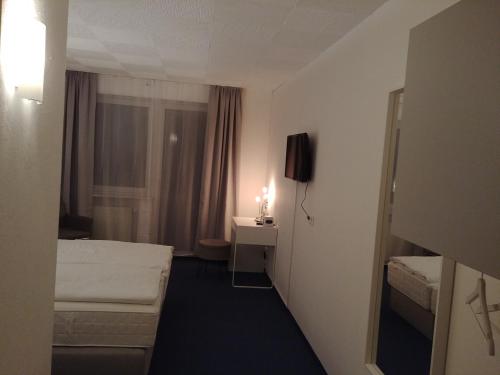 Zimmer mit 2 Betten, einem Schreibtisch und einem Fenster in der Unterkunft Hotel Panorama in Niederfüllbach