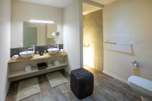 a bathroom with two sinks and a toilet at Oversteekhof in Roesbrugge-Haringe