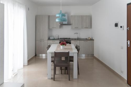 a kitchen with a white table and chairs in a room at CASA VITTORIA in Gravina in Puglia
