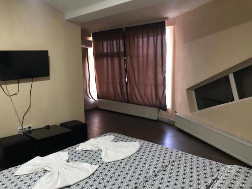 a room with a bed and a tv and a bed sidx sidx sidx at HotelWhite in Gjilan