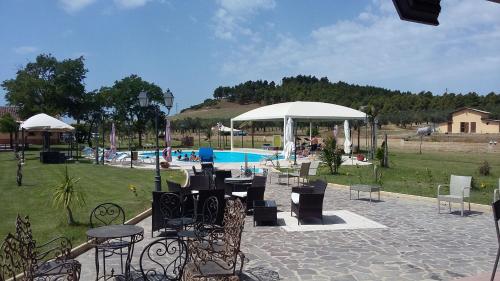 a patio with tables and chairs next to a pool at Agriturismo Fieri in Botricello