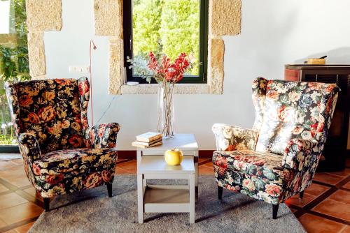 a living room with two chairs and a table at Bosque de Xarás, casa completa con encanto cerca de playa de Lapamán in Marín