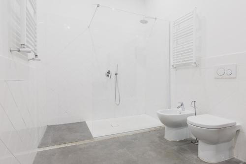 a white bathroom with a toilet and a shower at The Artists' Palace Florence in Florence