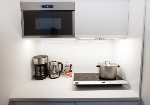 a kitchen counter with a stove and a microwave at Waterland Hoge Huis in Monnickendam