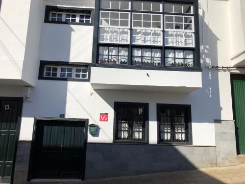 a white and black building with black windows at LOFT RURAL in Tegueste