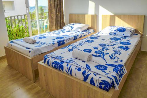 twee bedden met blauwe en witte lakens in een kamer bij Alise in Bar