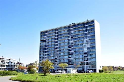 a tall building with a parking lot in front of it at SEA THE SEA - FEEL THE SEA - TOUCH THE SEA in Bredene