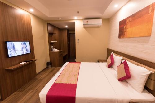 a hotel room with a bed and a tv at Le Roi Digha in Digha