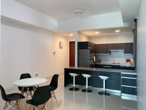 米里Bay Resort Condominium, 7, Beach-front Sea view, 6-8 PAX的厨房配有桌子和一些黑色椅子