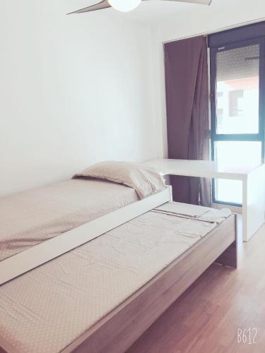 a white bed in a room with a window at HERMOSO ADOSADO EN GRAO DE CASTELLÓN in Grao de Castellón