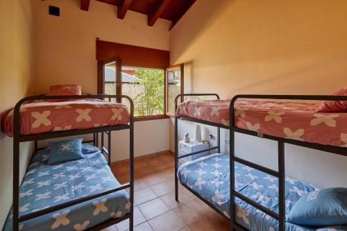 2 łóżka piętrowe w pokoju z oknem w obiekcie Ca LaMari w mieście Vidreres