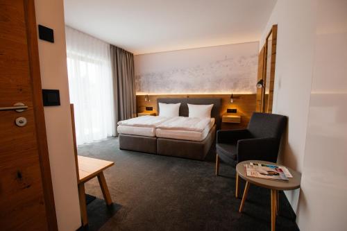 a hotel room with a bed and a chair at Hotel Tannenhaus in Schöneck