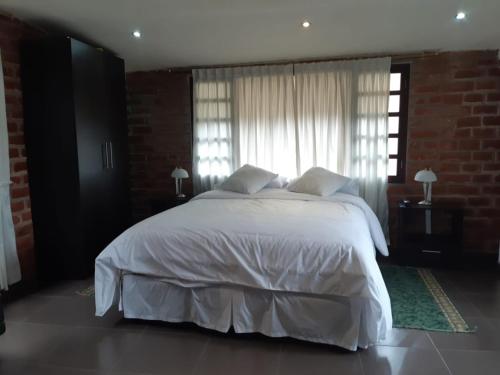 Een bed of bedden in een kamer bij El Pedron Hotel