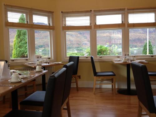 a restaurant with tables and chairs and windows at Buccleuch Guest House in Fort William