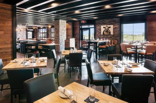a dining room with wooden tables and chairs at Cobblestone Hotel & Suites Appleton International Airport in Neenah