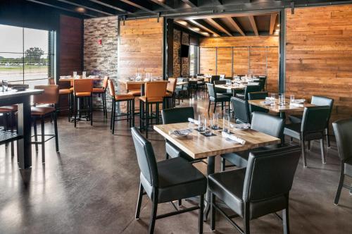 a restaurant with wooden walls and tables and chairs at Cobblestone Hotel & Suites Appleton International Airport in Neenah