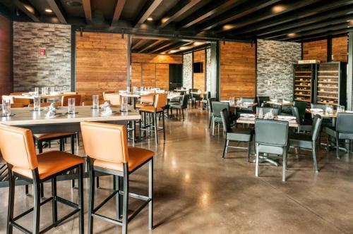 a restaurant with tables and chairs in a room at Cobblestone Hotel & Suites Appleton International Airport in Neenah
