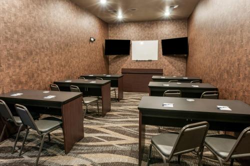 a conference room with tables and chairs and a podium at Cobblestone Hotel & Suites Appleton International Airport in Neenah