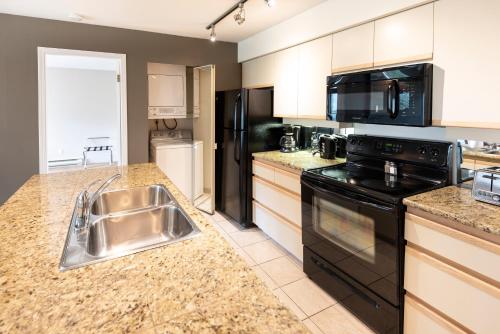 a kitchen with a stainless steel sink and appliances at The Ironwood on Blueberry Hill in Whistler