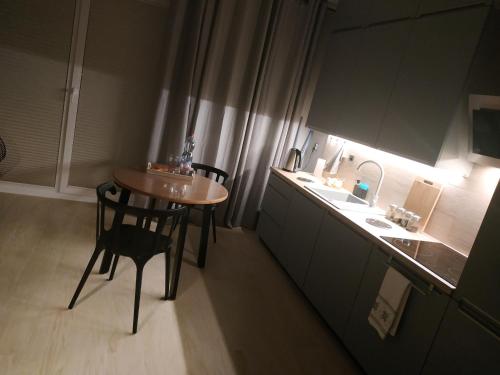a small kitchen with a small table and a sink at Apartament Limanowskiego 20/6 in Bartoszyce