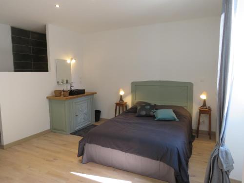 - une chambre avec un lit, un bureau et deux lampes dans l'établissement Gite du verger, à Mifaget