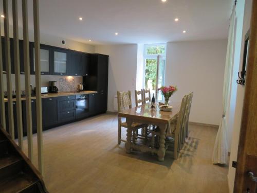 une cuisine et une salle à manger avec une table et des chaises dans l'établissement Gite du verger, à Mifaget