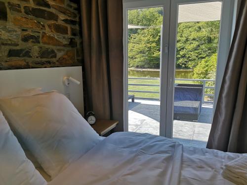 a bedroom with a bed and a sliding glass door at La Semois Et Moi in Rochehaut