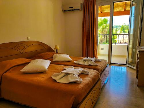 a hotel room with two beds with towels on them at Tria Adelphia in Arillas
